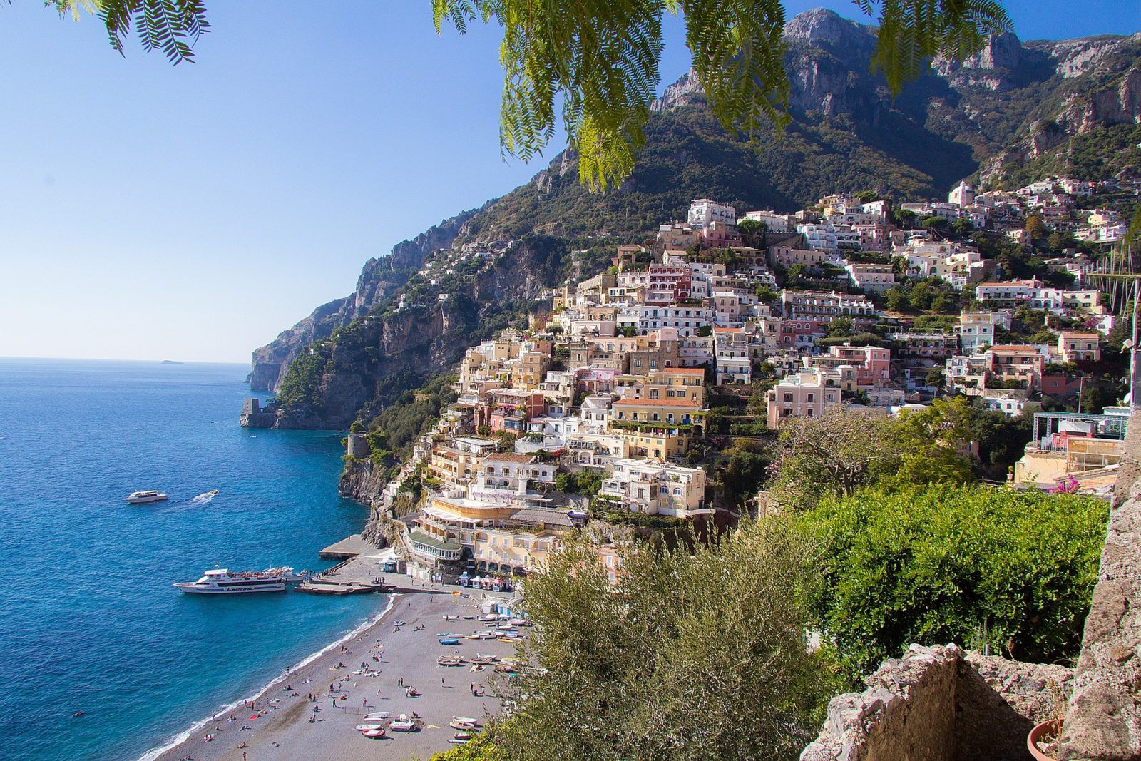 amalfi coastal village colorful hillside whitewashed buildings and pebbly beach on a clear day