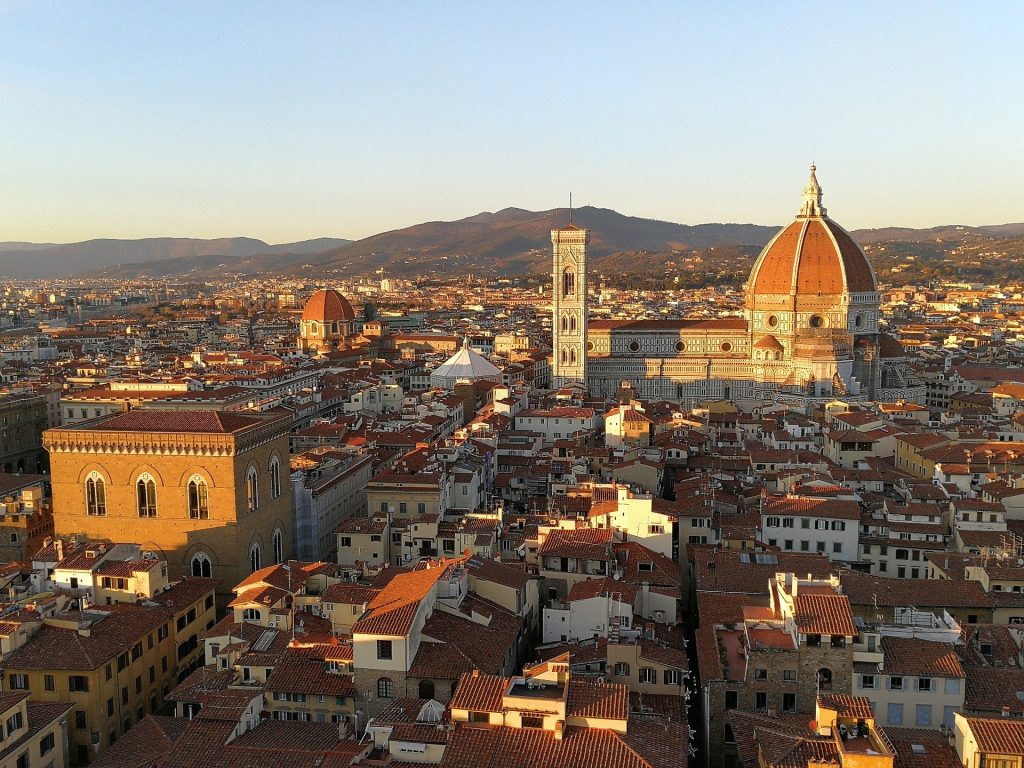 panoramic view of the heart of florence large basilica and hills in background during sunset