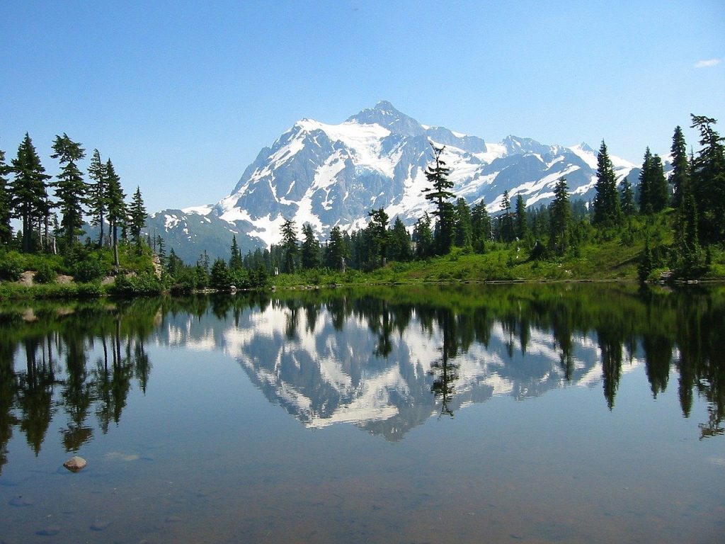 Mount Shuksan and its reflection in a crystal clear alpine lake seen in North Cascades National Park. The beautiful park is driving distance from Seattle, making for a perfect day trip from the city.