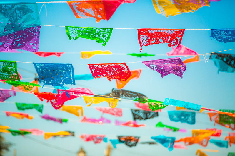 colorful traditional decorative flags waving in the air above a street in Todos Santos, a peaceful town 30 minutes away from Cabo. Todos Santos in Baja California Mexico.