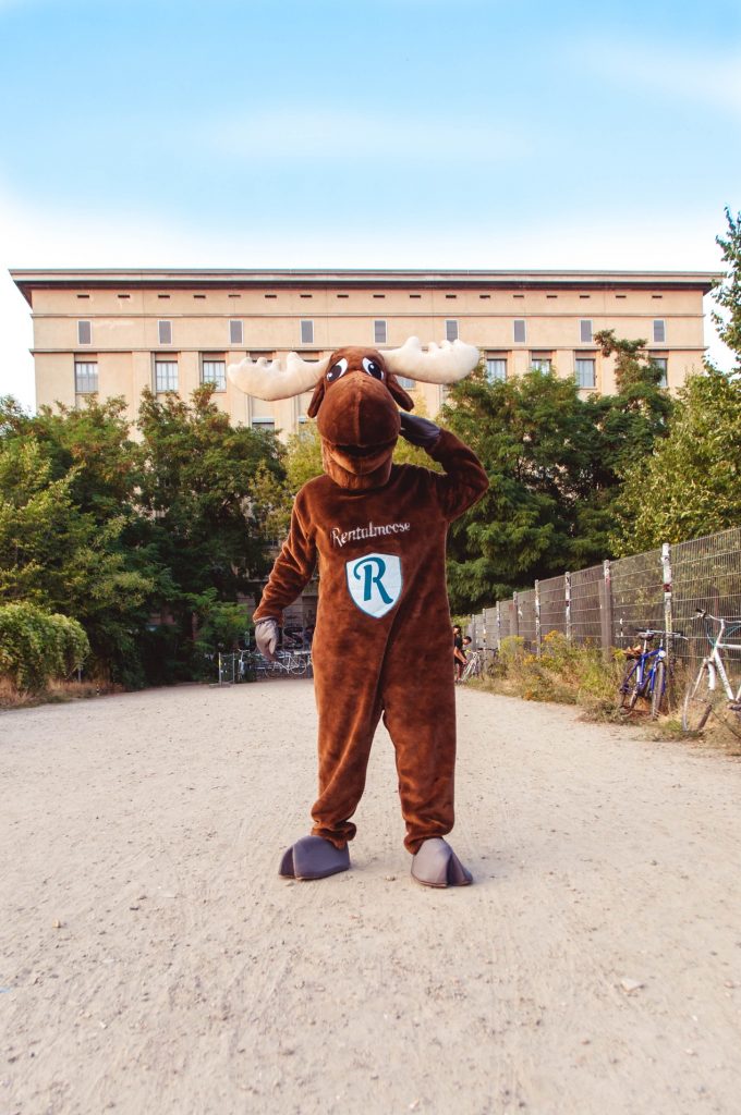 Rental Moose mascot posing in front of Berghain night club in Berlin during sunset. Berghain is a renowned techno club, one of the best underground clubs in Berlin.