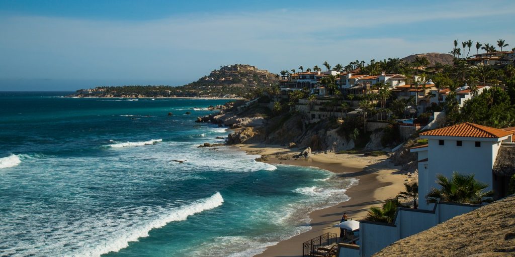 Shoreline of San Jose Del Cabo, beautiful tranquil sandy beaches and palm trees, as well as elevated whitewashed buildings.