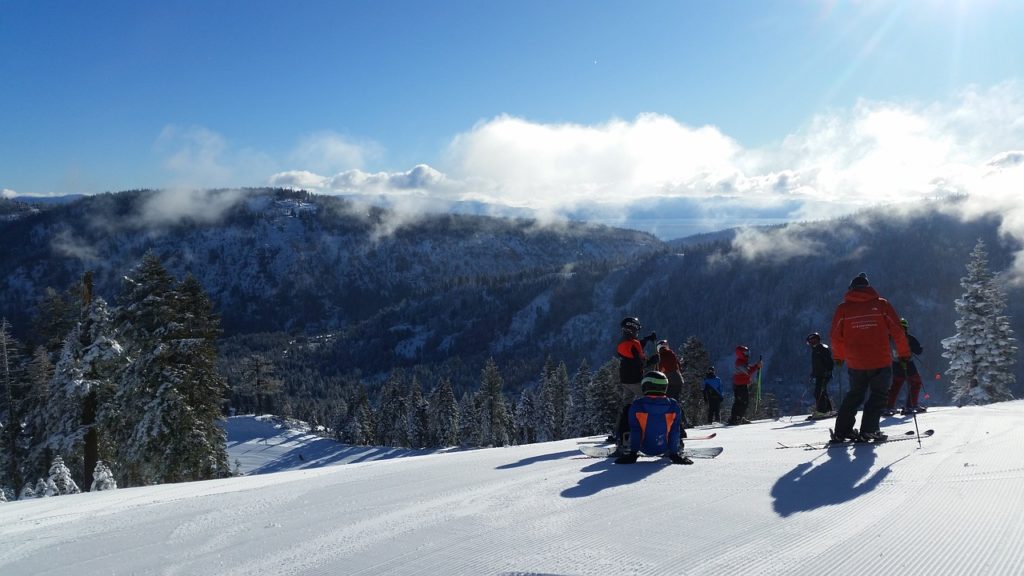 Skiing and snowboarding is one of the main reasons tourists visit Lake Tahoe in winter. Snowboarders admiring the view at one of Lake Tahoe's ski resorts.